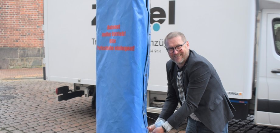 Bürgermeister Dirk Flörke deckt den Parkscheinautomaten ab.