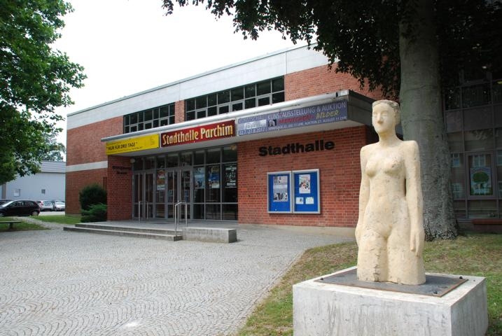 Stadthalle von vorne mit einer Skulptur