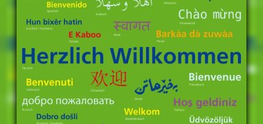 Plakat mit der Aufschrift "Herzlich Willkommen" in verschiedenen Sprachen