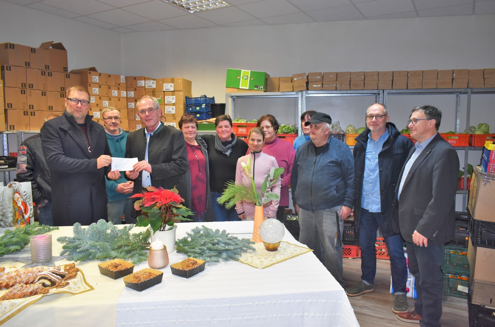 Im Beisein des gesamten Teams: Bürgermeister Dirk Flörke übergibt den Fördermittelbescheid der Stadt Par-chim an den Vereinsvorsitzenden der Parchimer Tafel, Jürgen Fokuhl. 