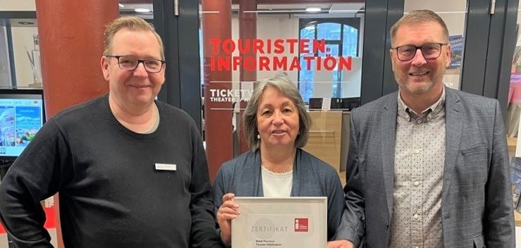 Bärbel Sawatzki und Steffen Struck von der Touristinformation Parchim und Bürgermeister Dirk Flörke präsentieren das erneuerte Zertifikat. 