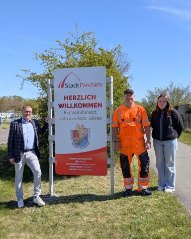 Bürgermeister Dirk Flörke präsentiert mit Angestellten der Stadt Parchim die neuen Schilder am Parchimer Ortseingang.
